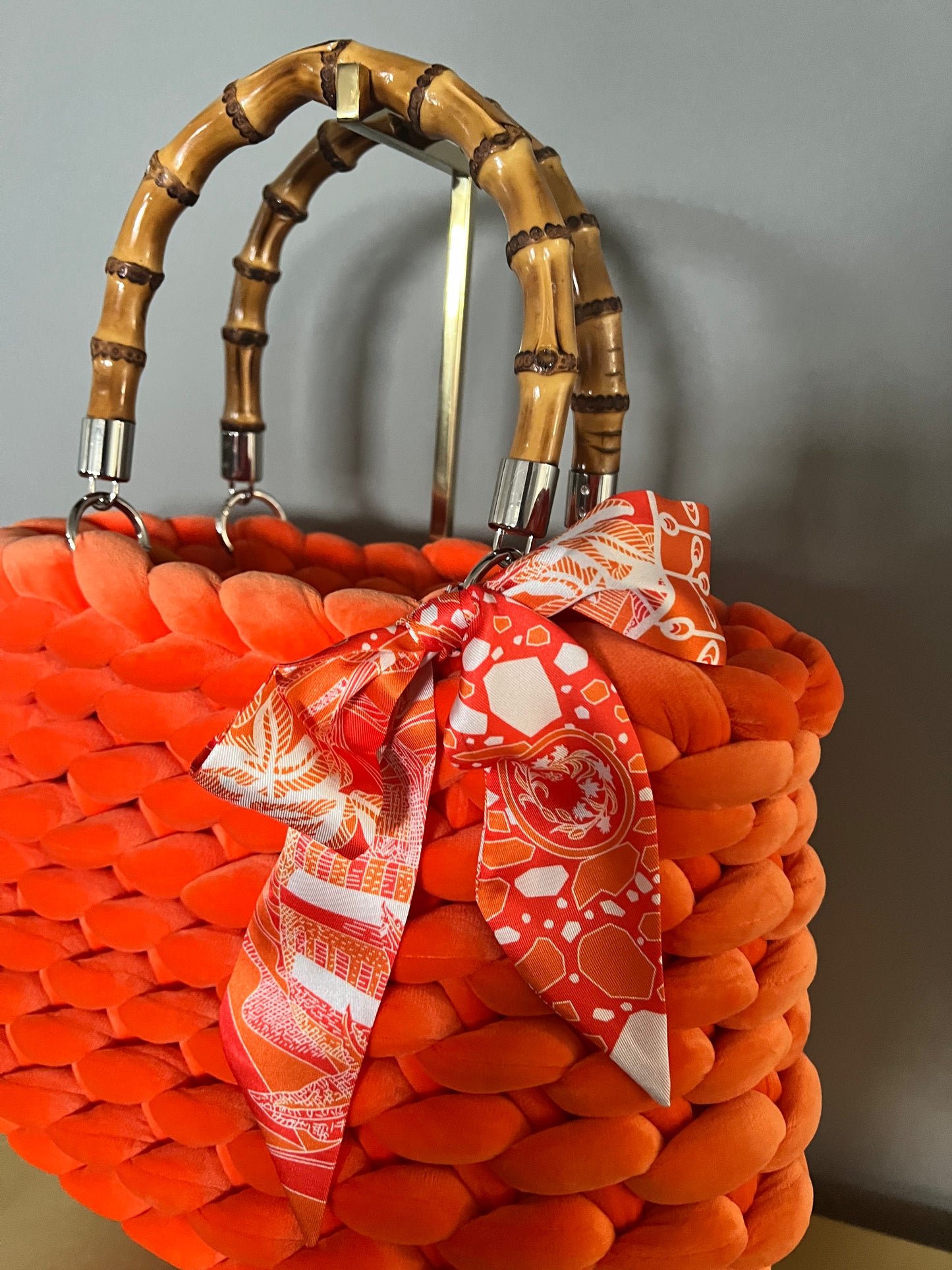 Sac classique en grosse maille en velours orange avec poignées en bambou et détails argentés